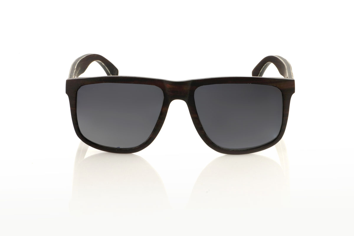 Gafas de Madera Natural de Ébano RAMONE. Las gafas de sol de madera RAMONE, con su diseño cuadrado y bordes suavemente redondeados, son la elección perfecta para quienes tienen caras más anchas y buscan un accesorio que combine comodidad y estilo. Fabricadas íntegramente en madera de ébano, estas gafas destacan por su robustez y elegancia natural. El interior, enriquecido con varias láminas de madera de arce, no solo aporta un contraste visual interesante, sino que también refleja un cuidado excepcional en la fabricación. Con unas medidas de 145x50 y un calibre de 56, las RAMONE prometen un ajuste óptimo y una durabilidad superior, ideales para el día a día o para momentos especiales. Venta al Por Mayor y Detalle | Root Sunglasses® 